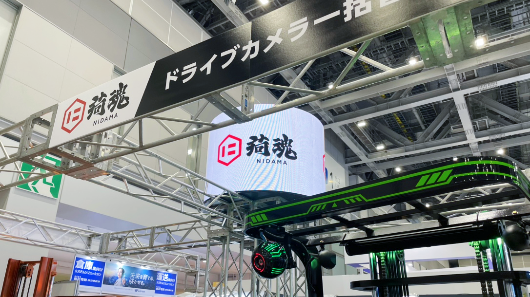 ブース上部の円柱型LEDビジョンとブース全景